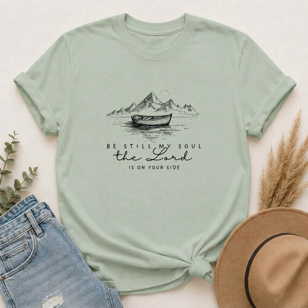 T-Shirt – “Be Still My Soul, the Lord Is On Your Side” Boat & Mountains Faith Tee